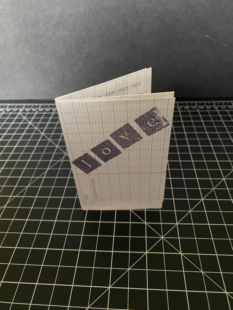 front cover of the zine with title "love:an accounting" printed on graph paper